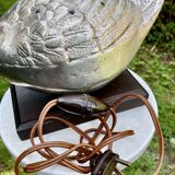 Old vintage lamp representing a duck in silver metal with wooden base