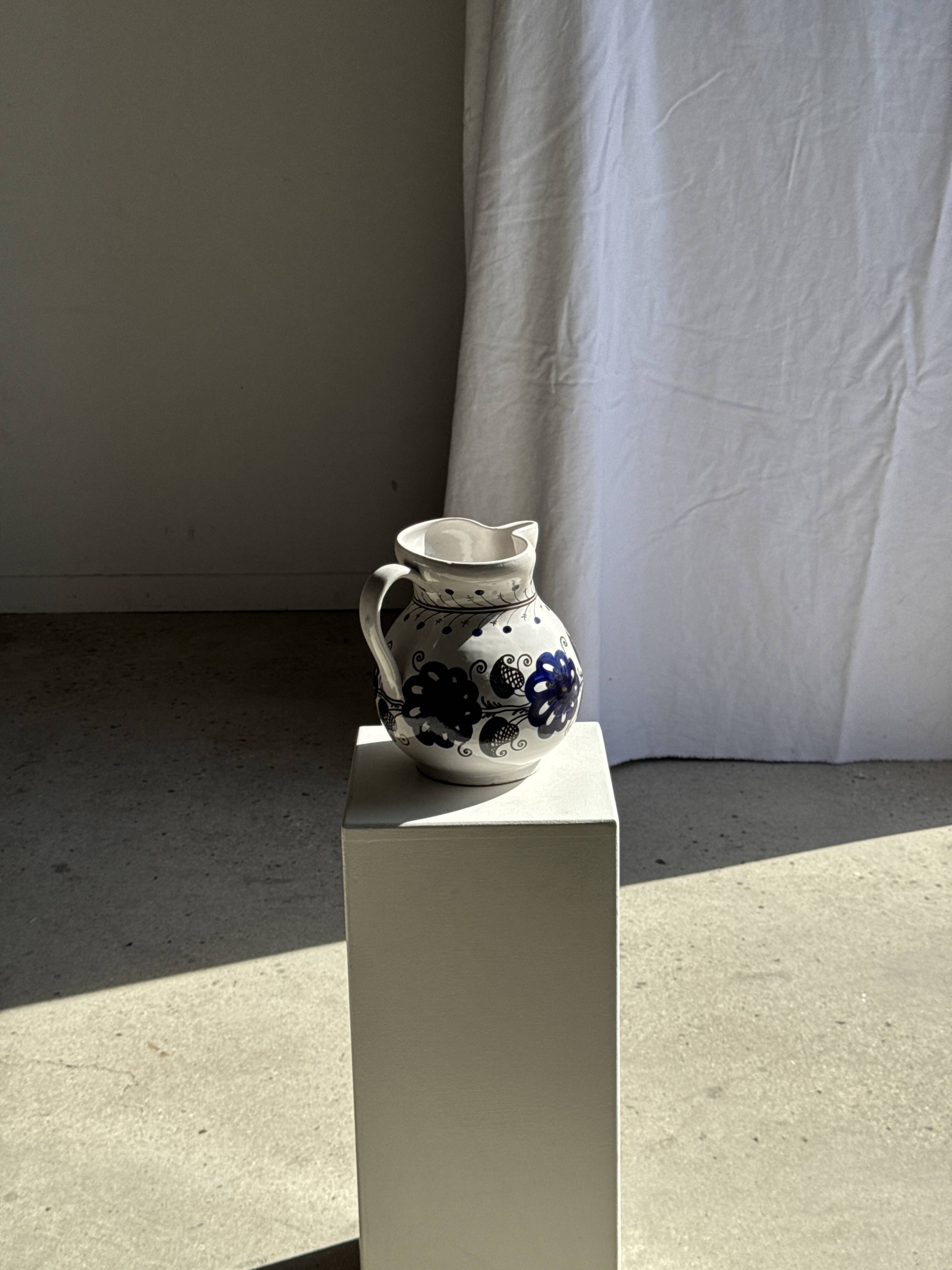 Very large vintage ceramic carafe in white glazed with blue floral decoration.