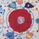 White suzani kilim rug with hand embroidered multi-colored patterns