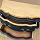Curved commode painted in black and wood.