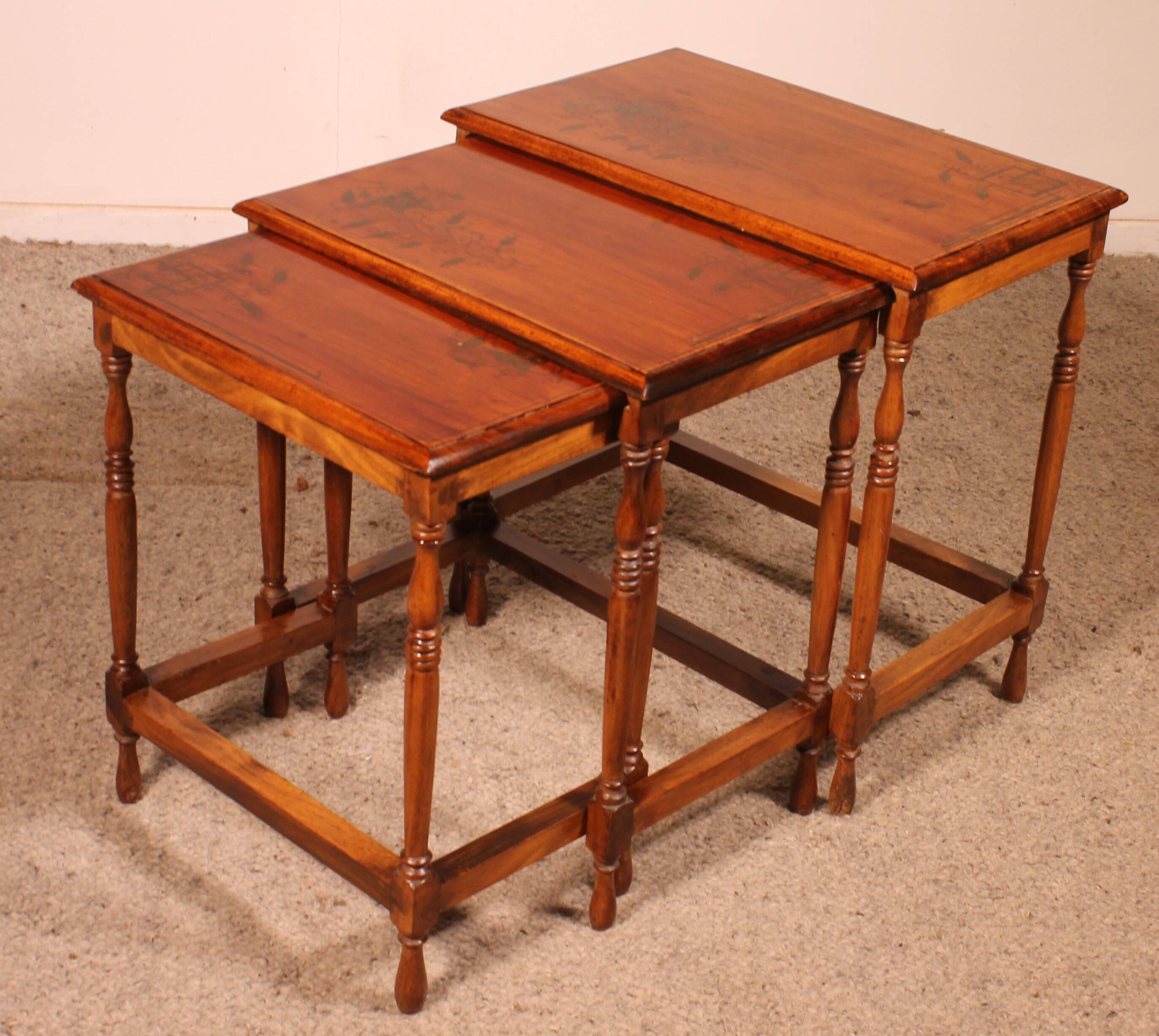 Nested tables in satin wood with brass inlays.
