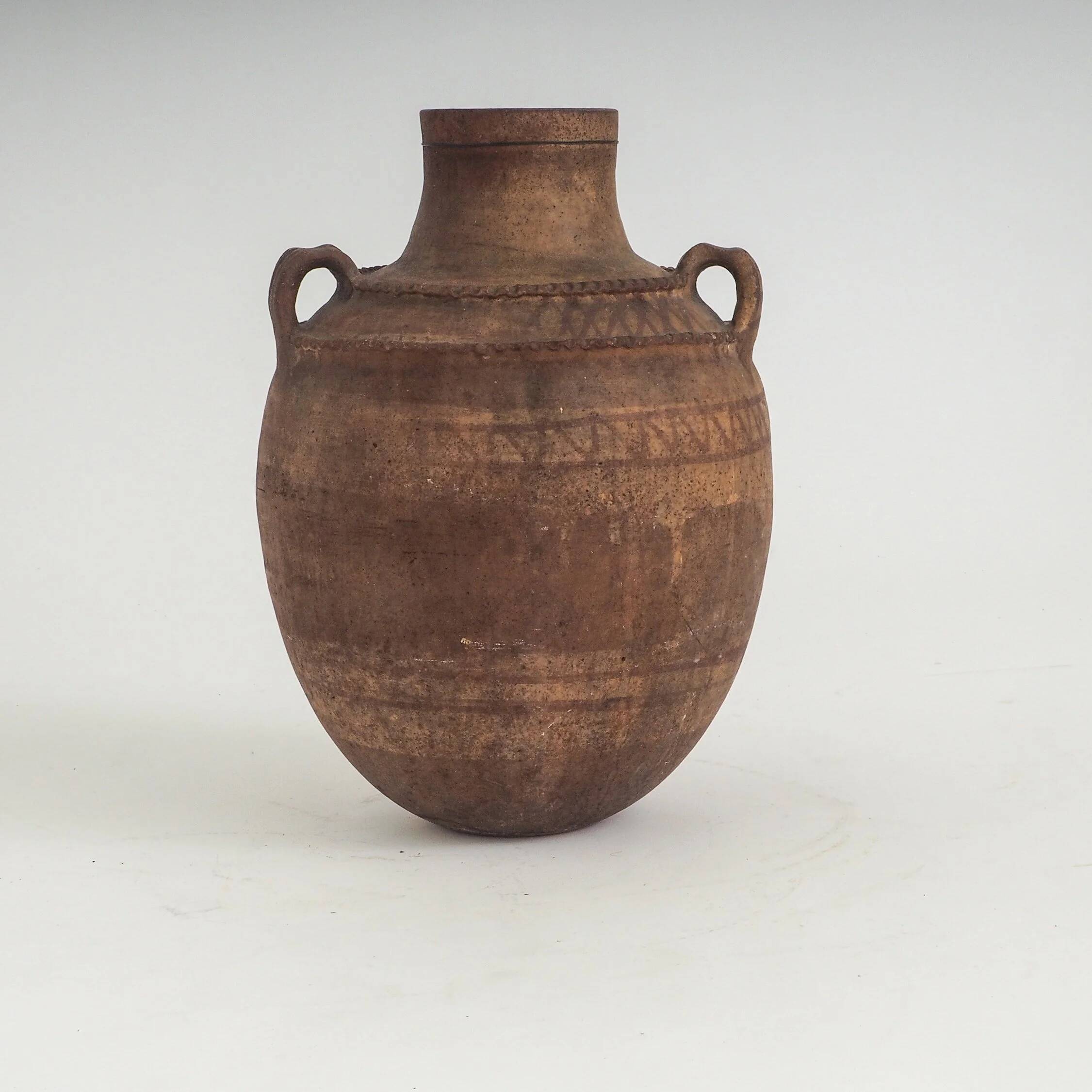 Vaisseau en terre cuite primitive avec des détails géométriques peints à la main.