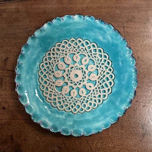 Assiette en émail fond bleu XXe ornementée d'une dentelle