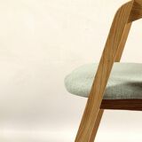 Vintage dining chair in light oak with natural linen pastel green fabric.
