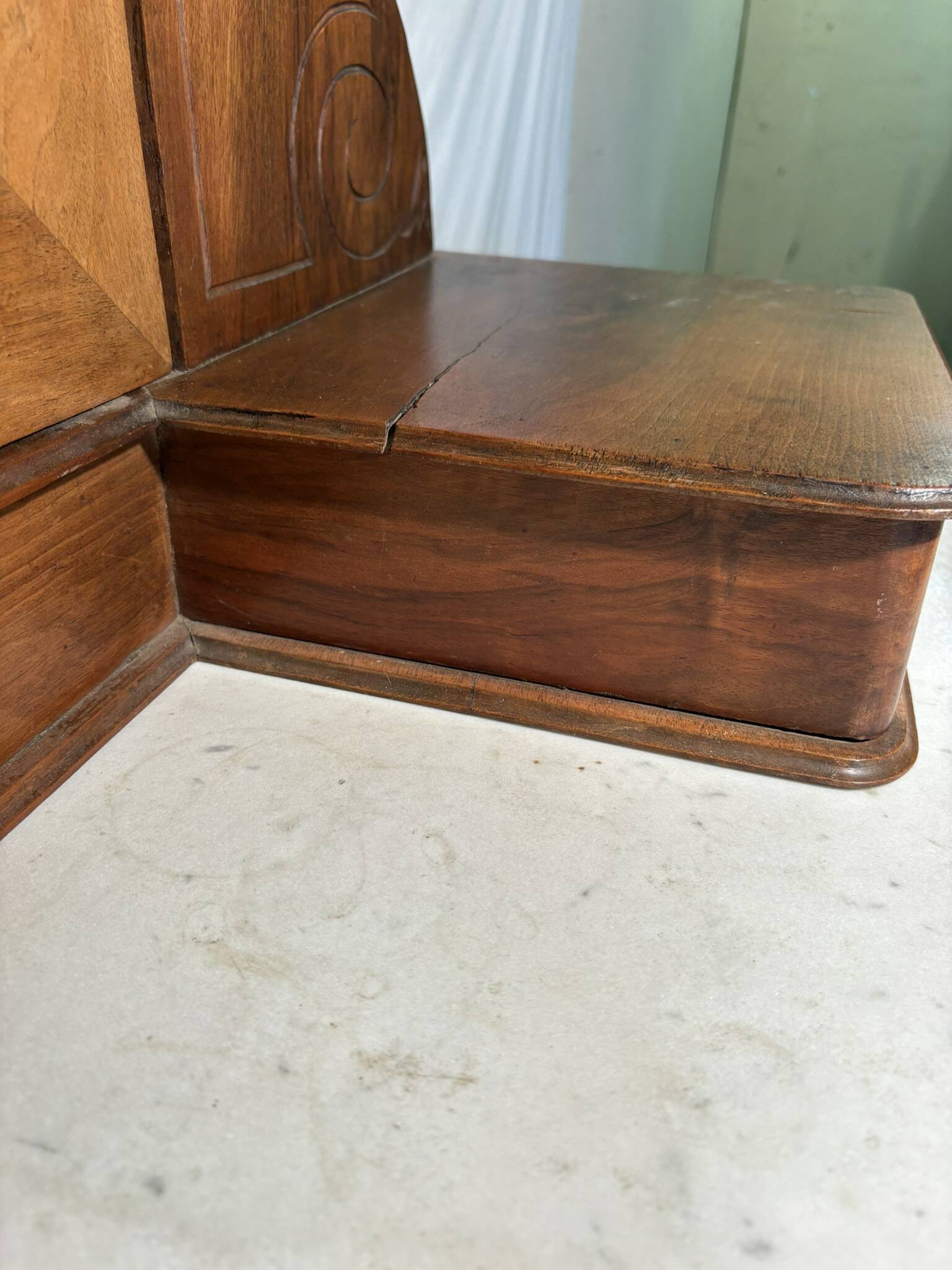 Antique carved wooden dressing table with marble and tilting oval mirror.