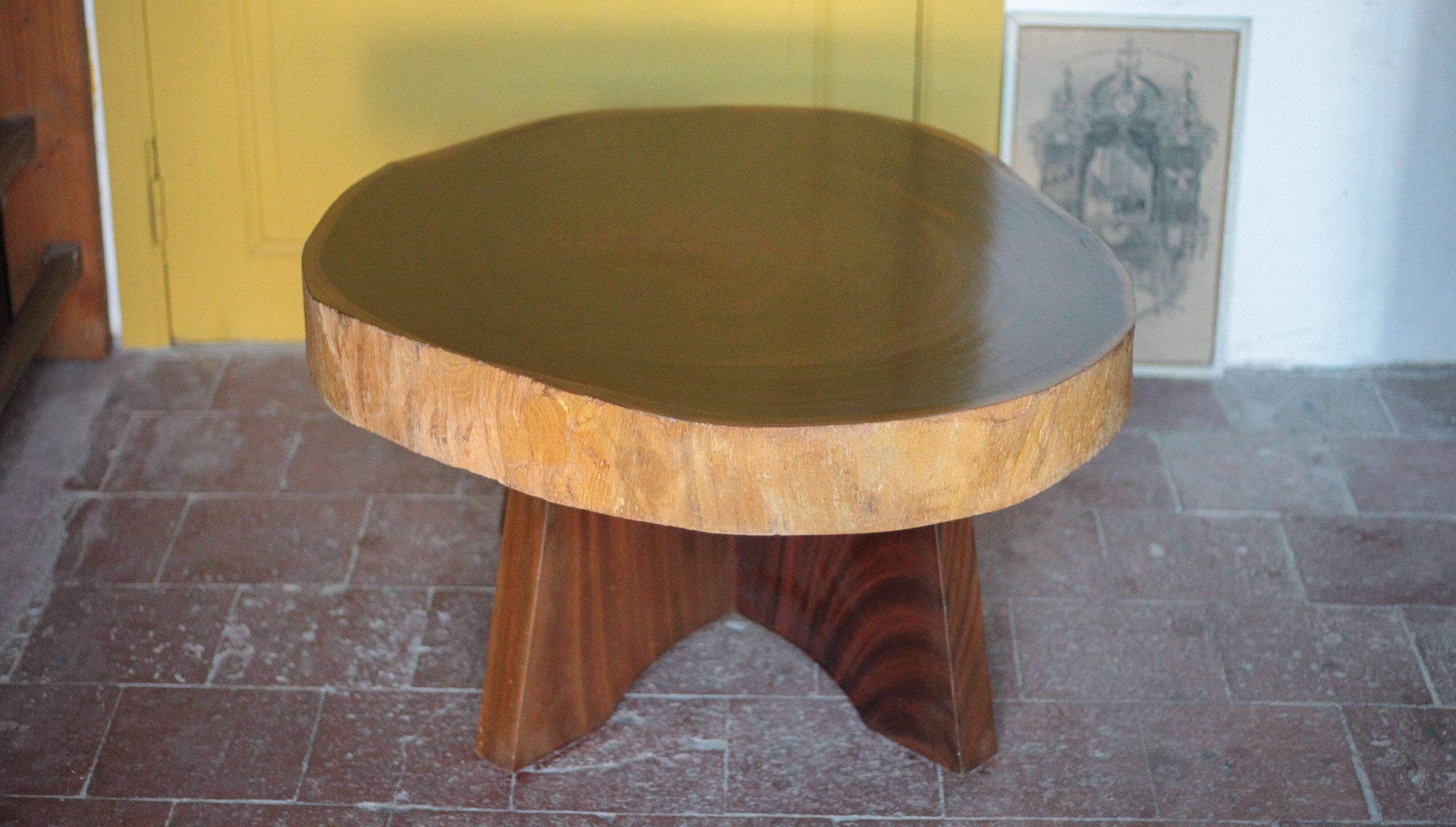 Brutalist wooden coffee table, cruciform leg with a tree trunk top.