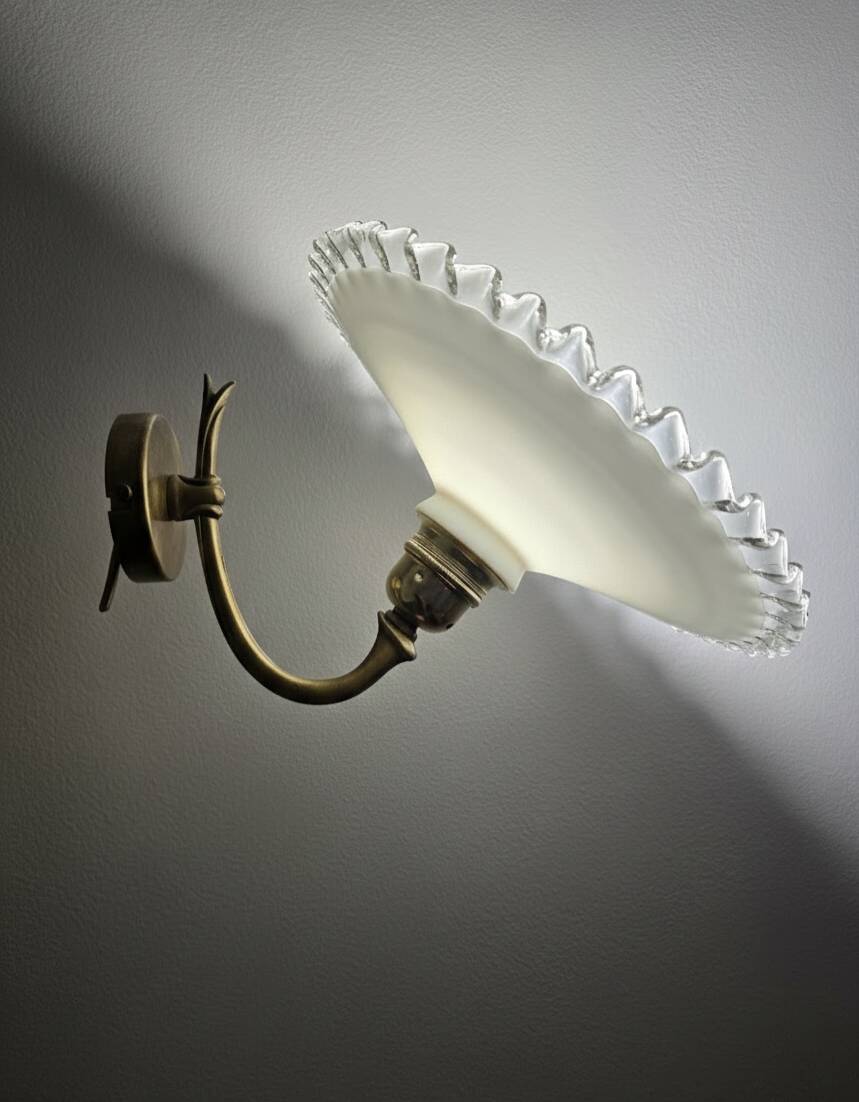 Wall sconces with scalloped opaline lampshades.