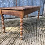 Antique farmhouse table in solid cherry wood with turned legs.
