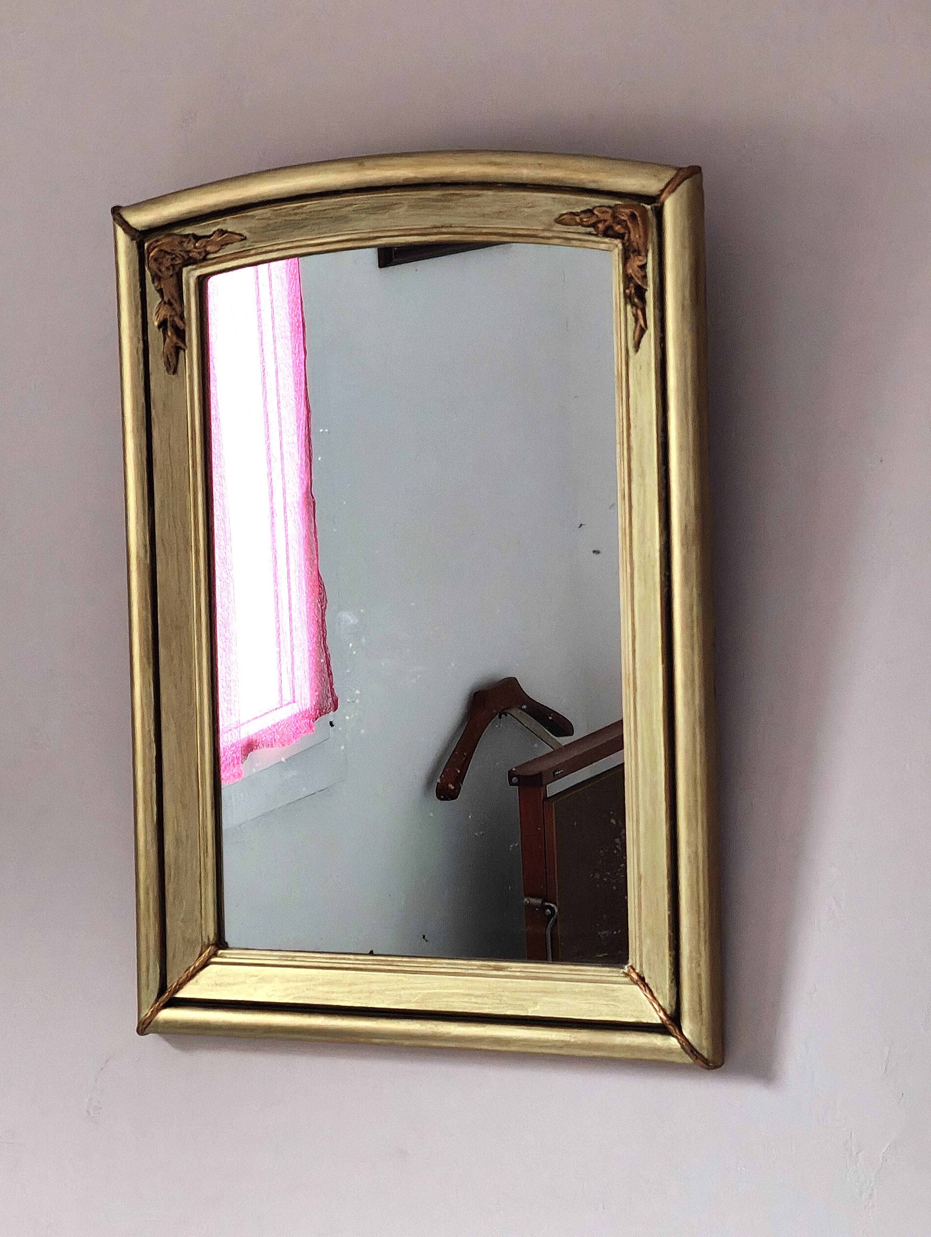 Art Deco mirror in gilded wood with curved floral decorations.
