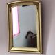 Art Deco mirror in gilded wood with curved floral decorations.
