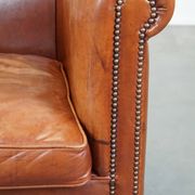 Cognac-colored cow leather club chair finished with decorative nails in English style