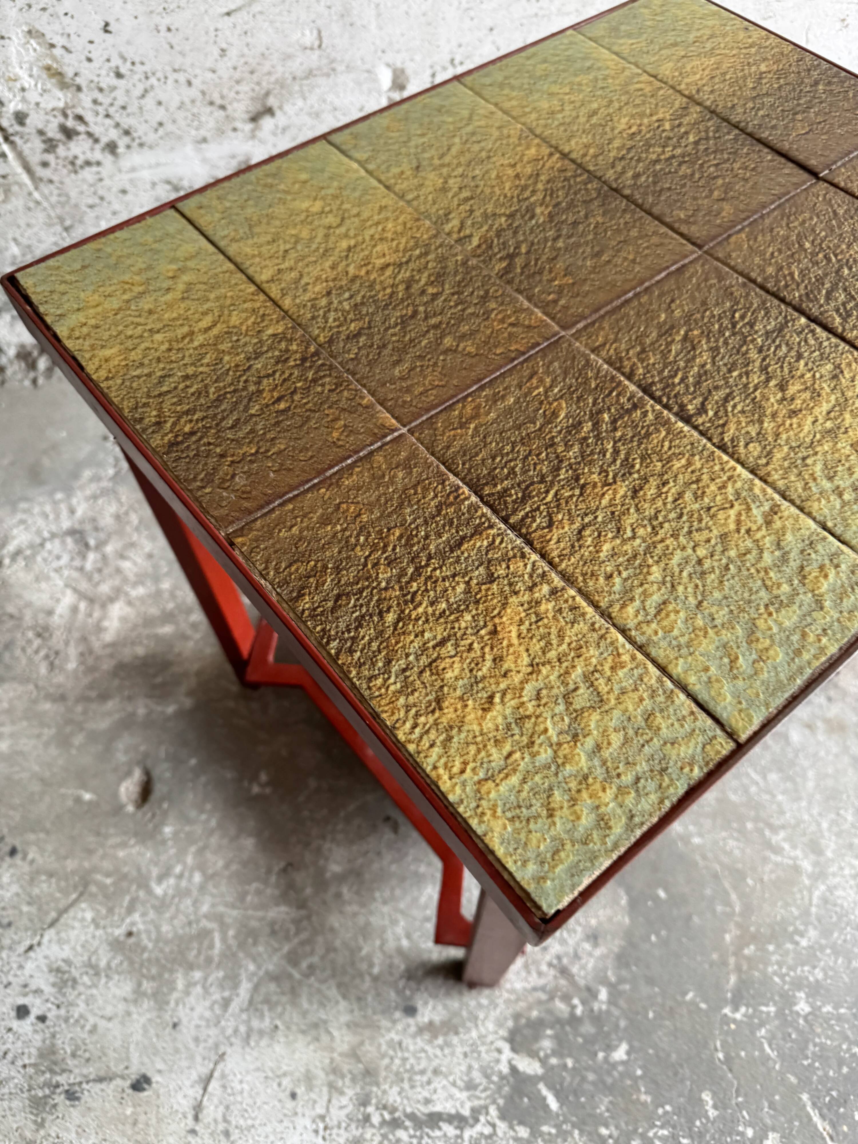 Vintage terracotta-red metal side table with glazed brown-green ceramic tile surfaces