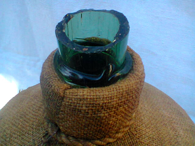 Demijohn dressed in burlap and padded cork