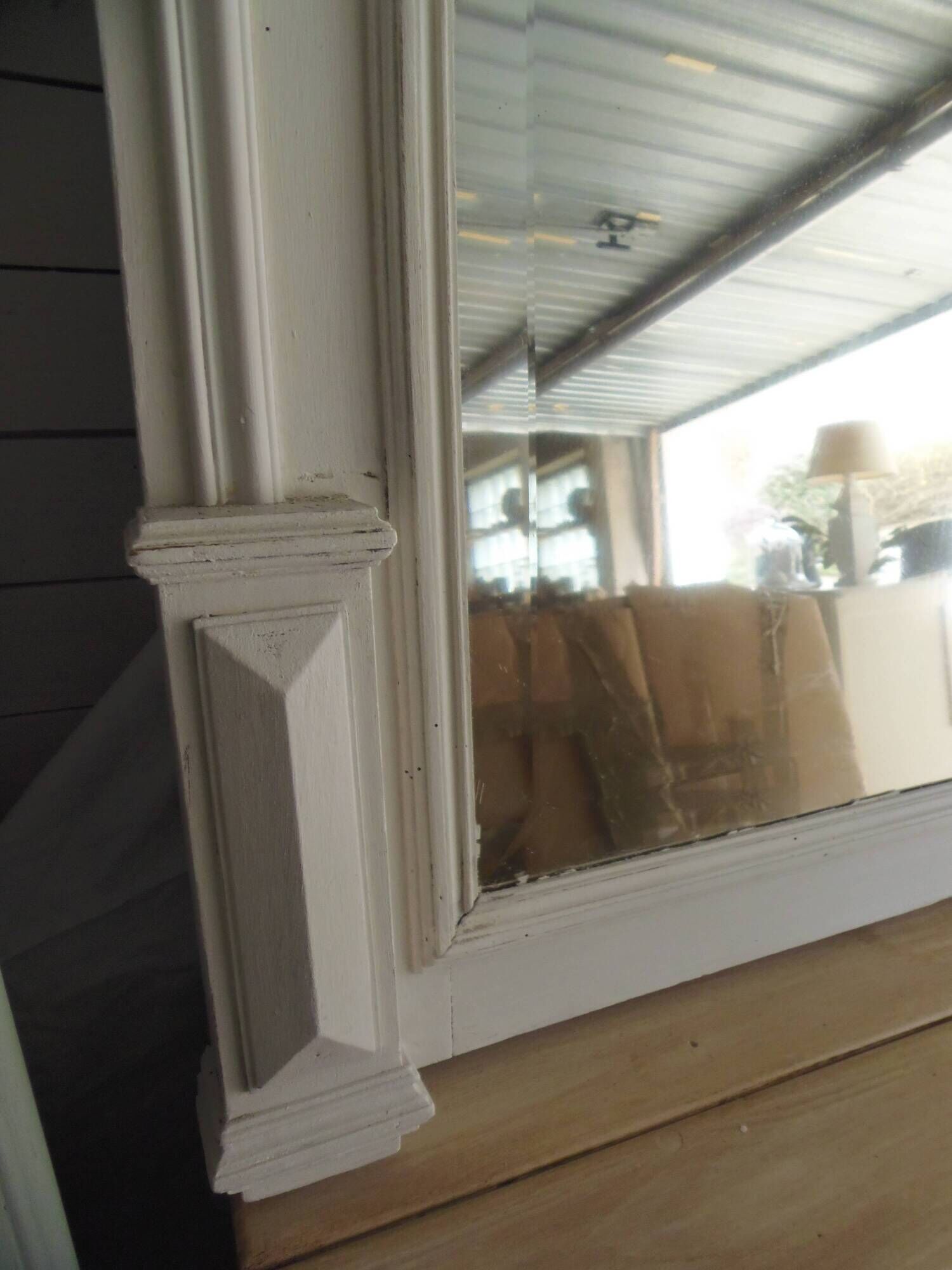 Miroir ancien biseauté, cadre en bois et stuc patiné gris perle.