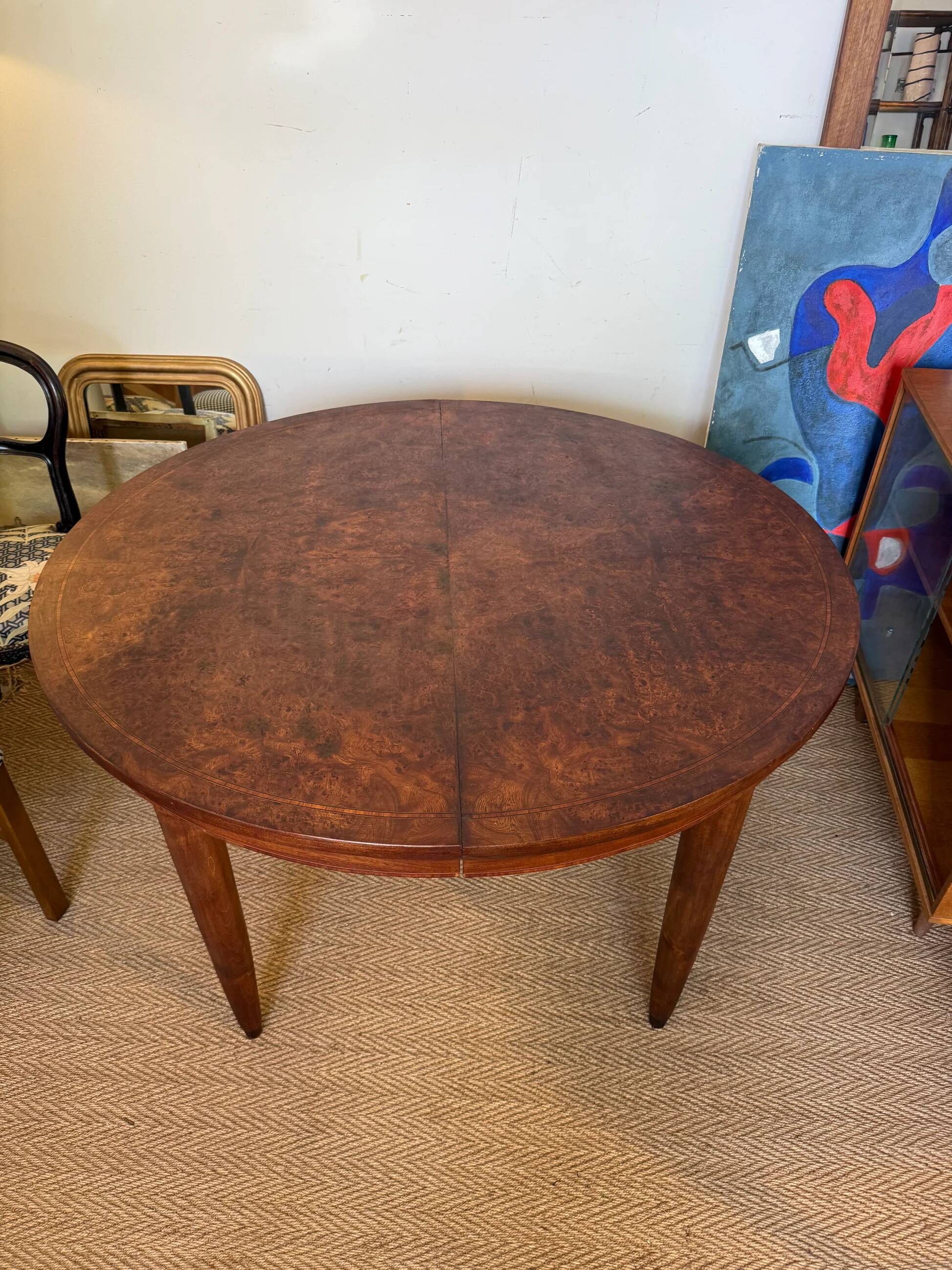 Oval extendable dining table in wood and walnut burl veneer.
