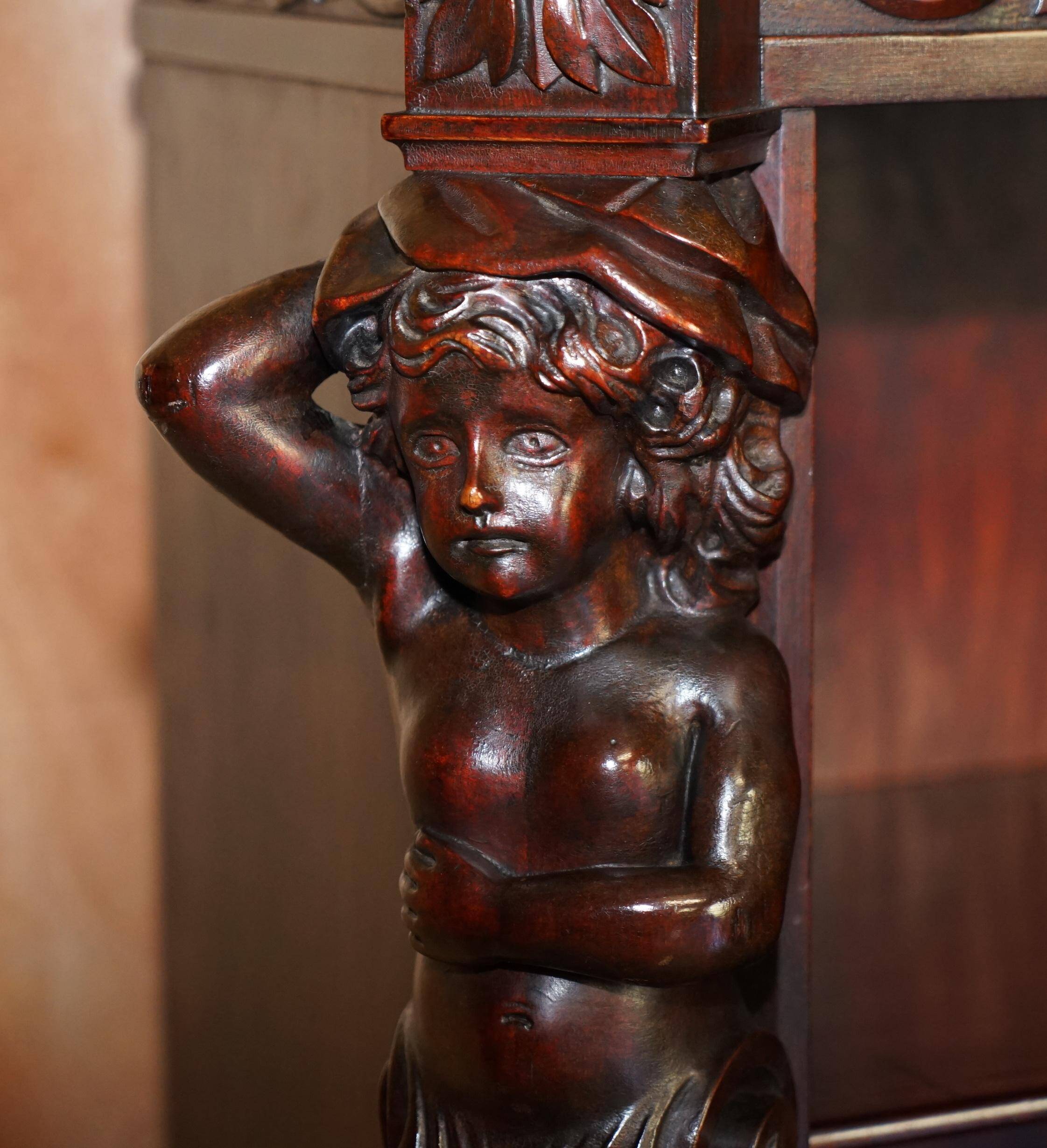Hand-carved library circa 1900 in hardwood with Hermes statues.