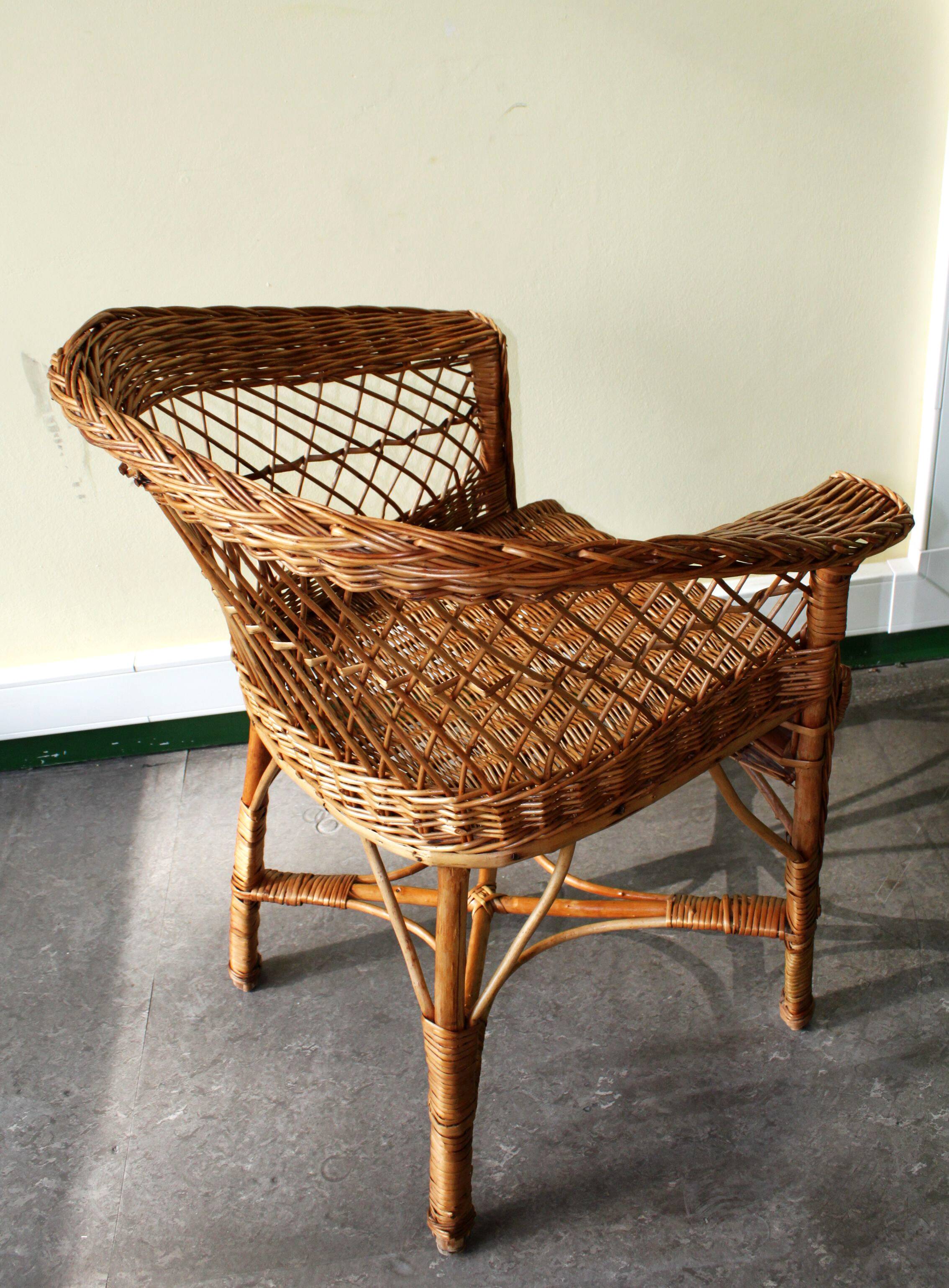Woven rattan armchair with armrests.