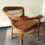 Woven rattan armchair with armrests.