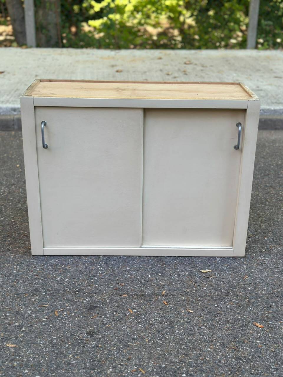 Vintage wall-mounted kitchen cabinet with sliding doors in 1960s retro style.