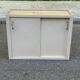 Vintage wall-mounted kitchen cabinet with sliding doors in 1960s retro style.