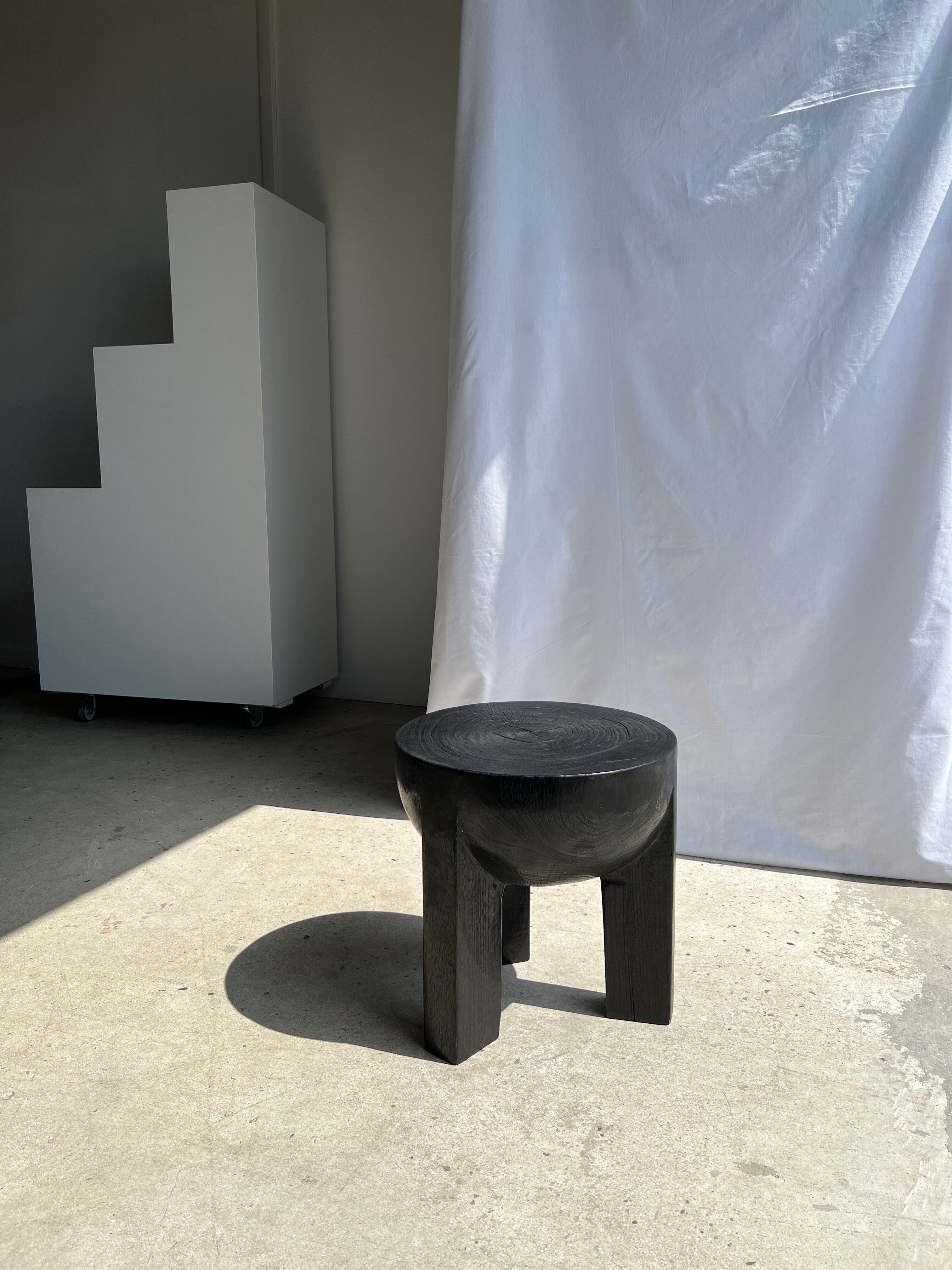 Black mango wood tripod side table with a semi-spherical top, height: 45 cm, diameter: 44 cm.