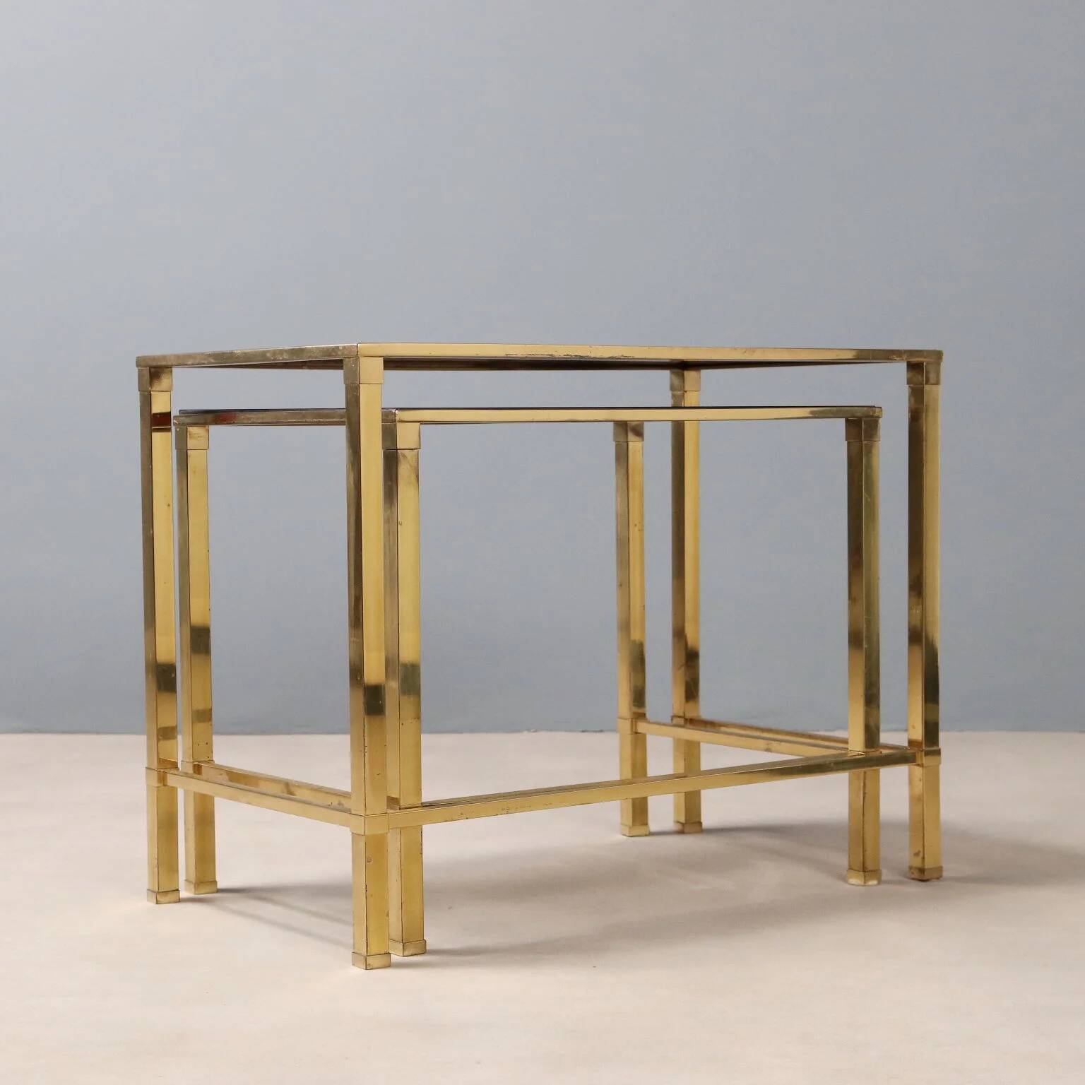 Nested tables in brass and smoked glass.