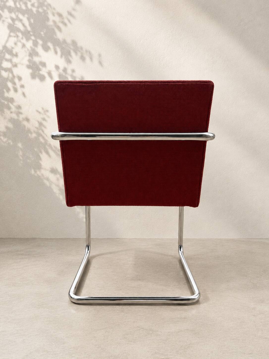 Vintage cantilever chair in chrome and burgundy fabric.