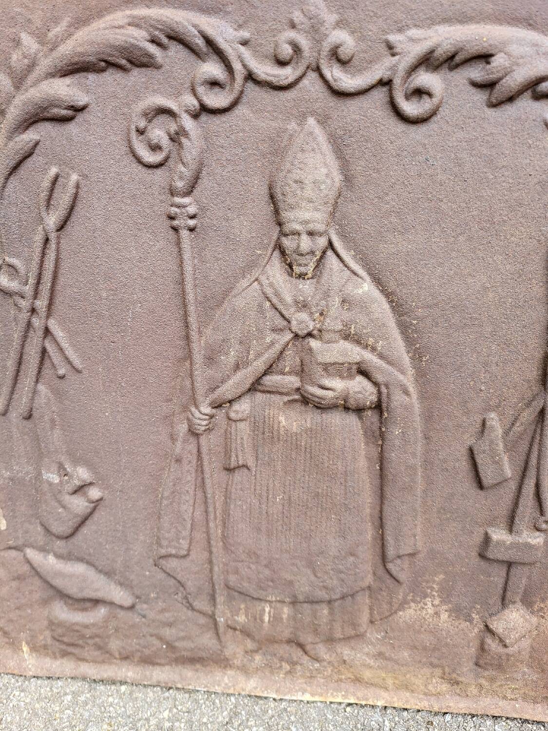 19th century cast iron fireback: bishop blessing the blacksmith's tools