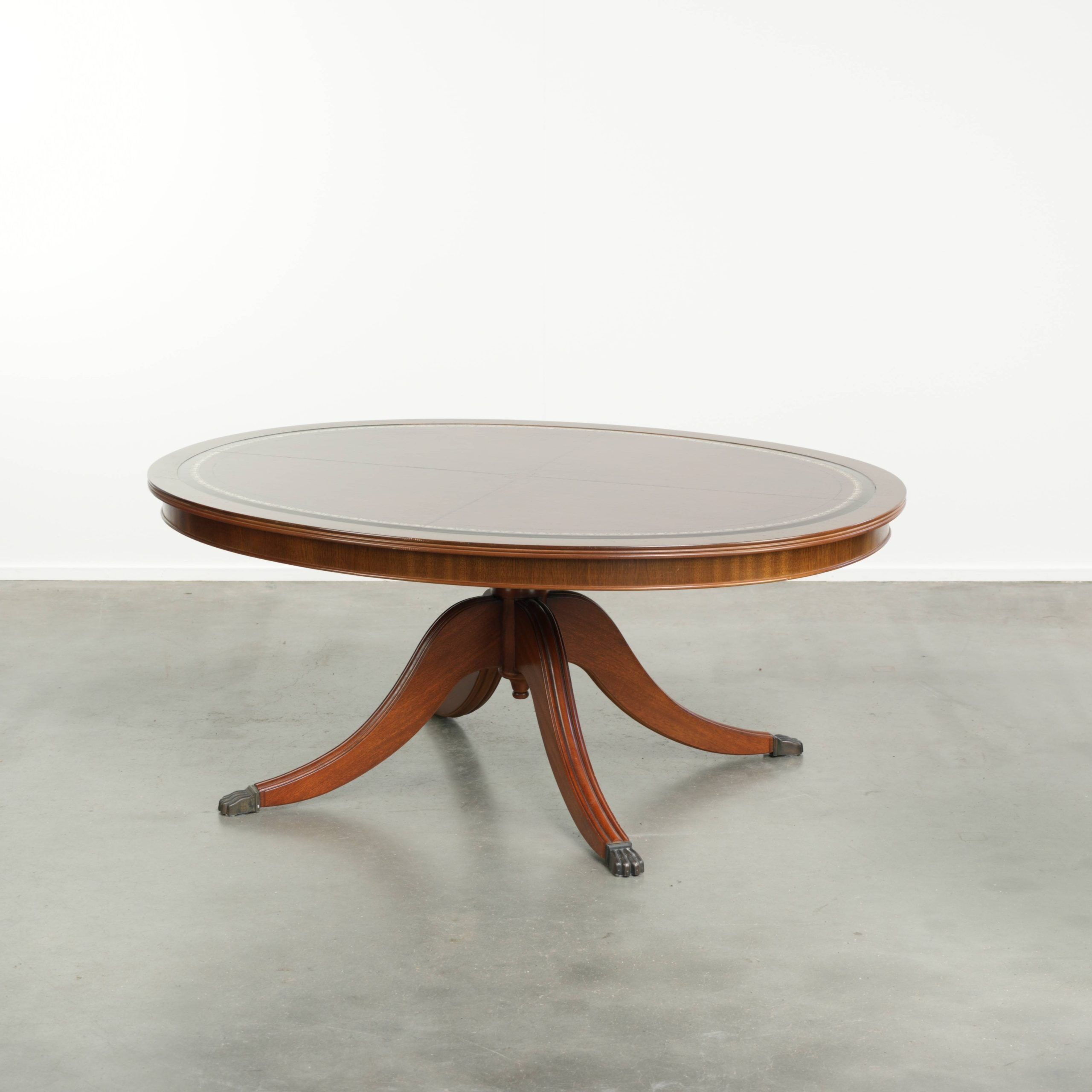 Table basse avec un plateau en cuir rouge de style anglais du 20e siècle.