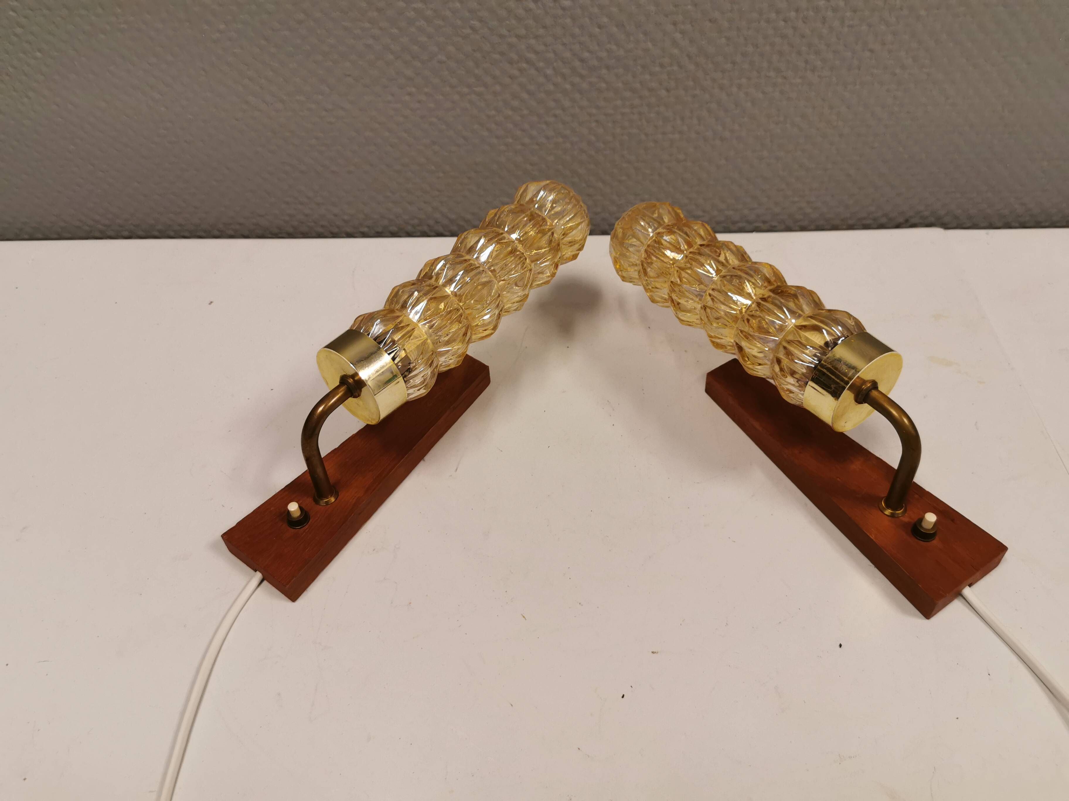A set of Danish wall lights in champagne coloured glass with brass and teak.