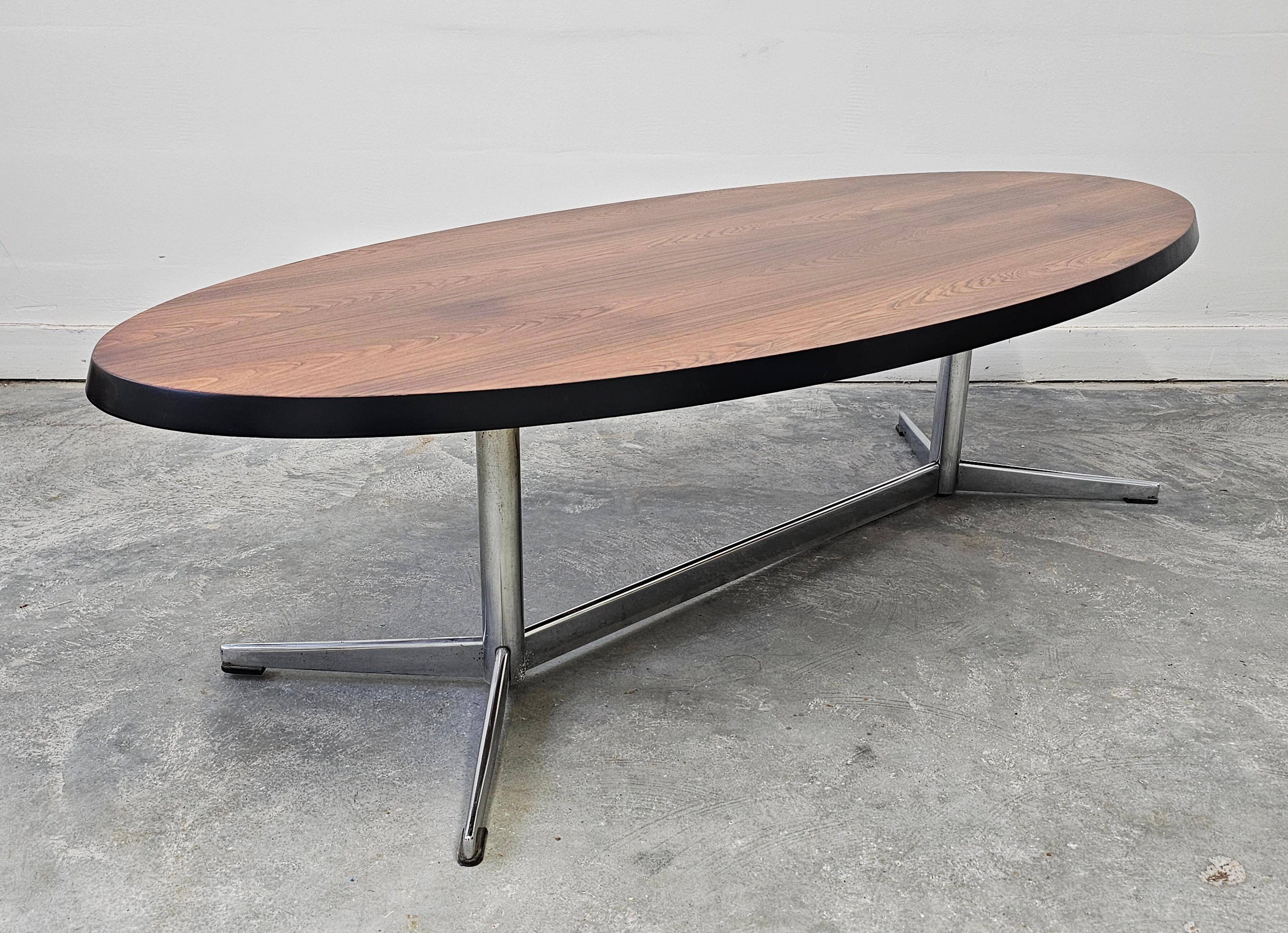 Danish Mid Century Modern oval coffee table with a teak top and chrome legs.