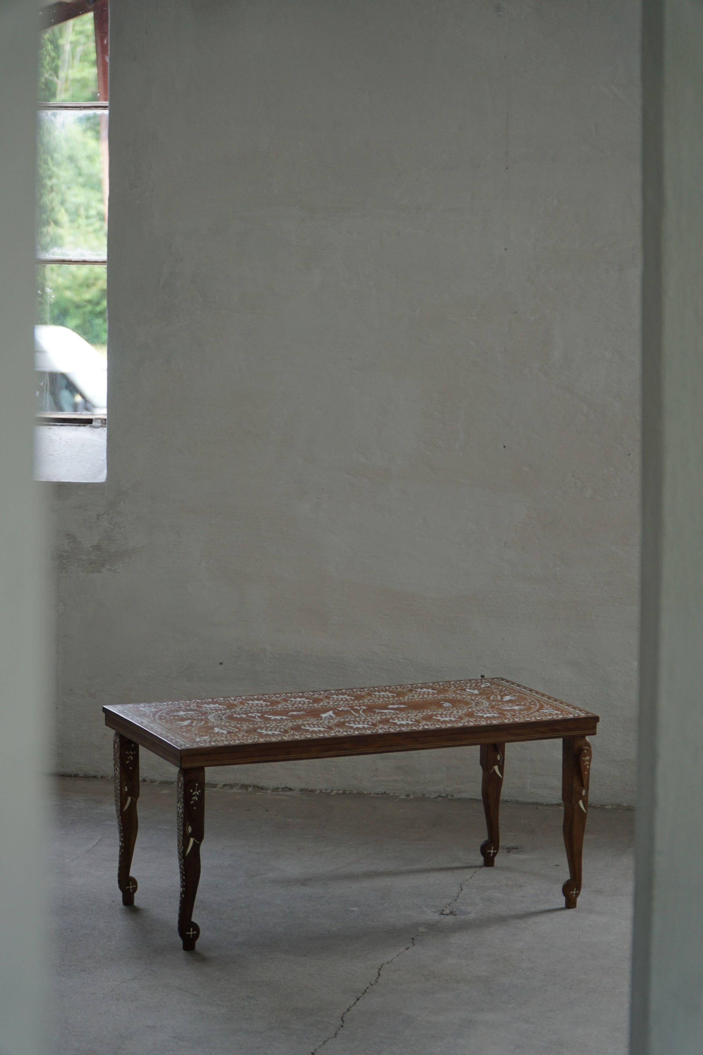 Vintage Indian teak coffee table inlaid with elephant motifs, mid-20th century.