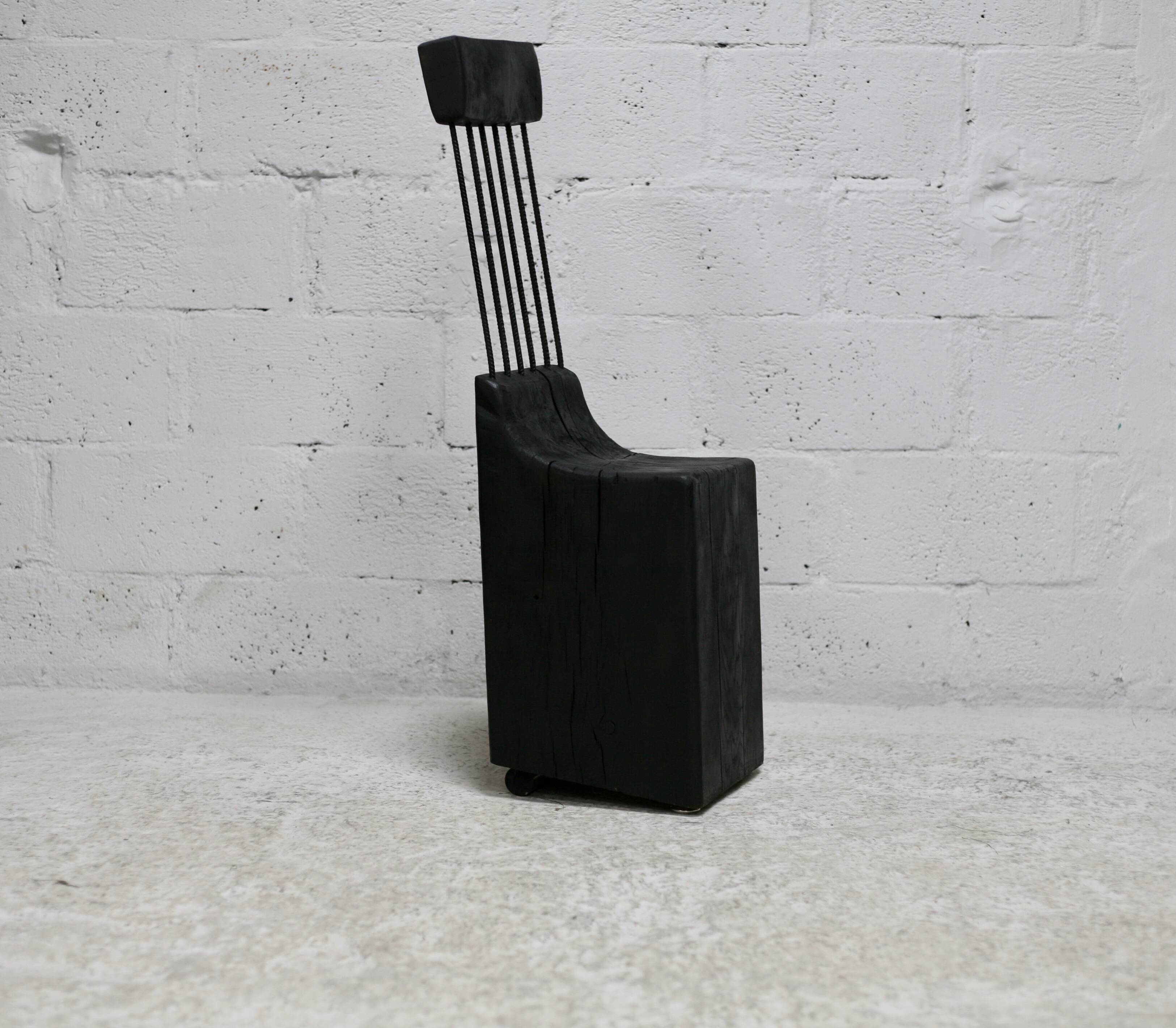 Brutalist chair, black-stained raw wood, steel. Work from the 1970s
