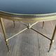 Round coffee table in brass with a black lacquered glass top from Maison Jansen.
