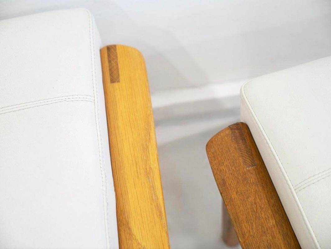 Paire d'ottomans tapissés en teck et cuir blanc