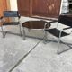 Mid-century round coffee table in chrome and smoked glass with 2 black leather chairs.