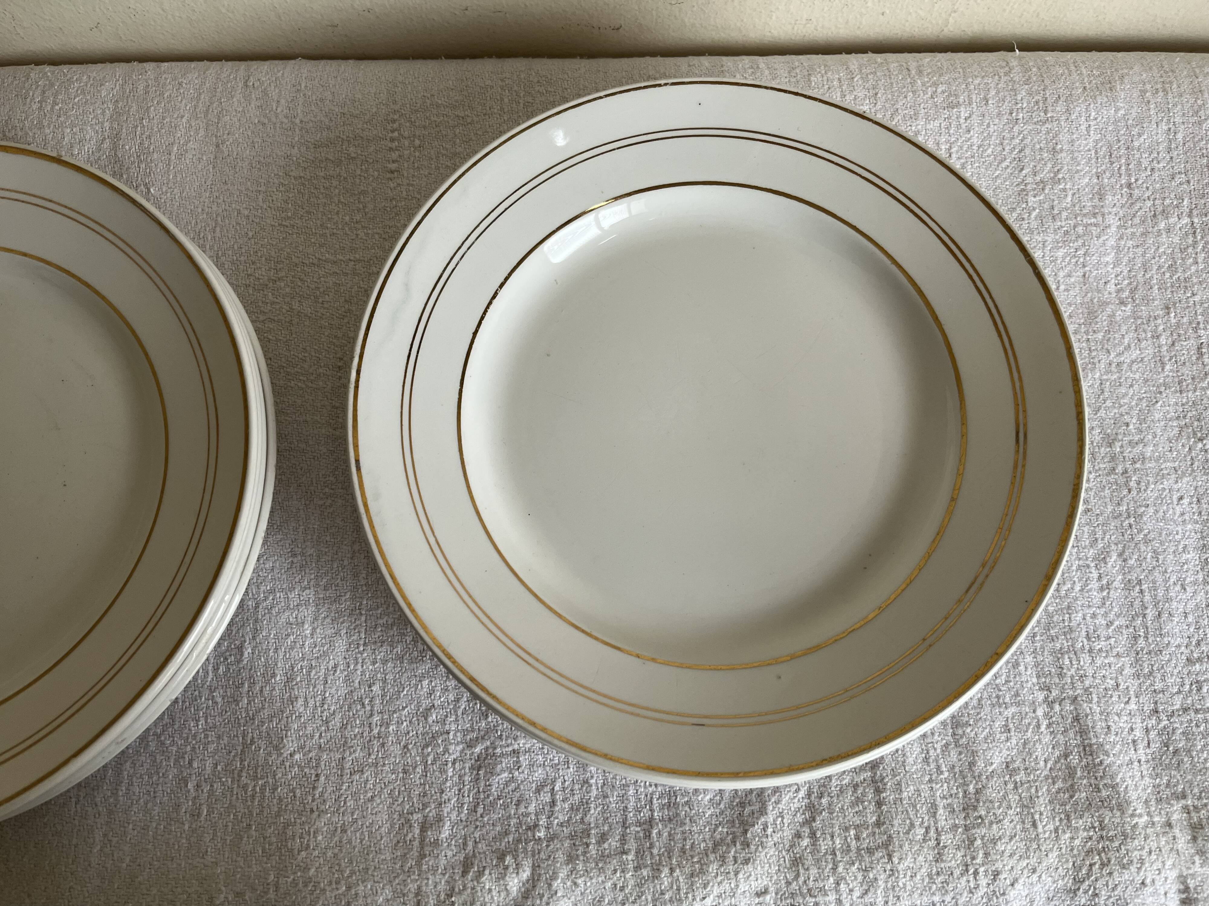 Set of 8 modernist flat plates in fine earthenware with pure gold trim, 1930.