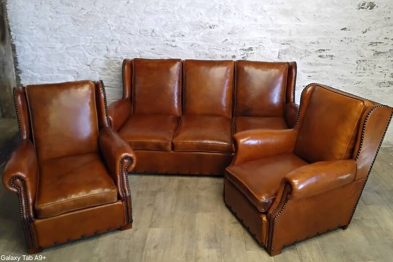 Living room with a sofa and wingback armchairs.