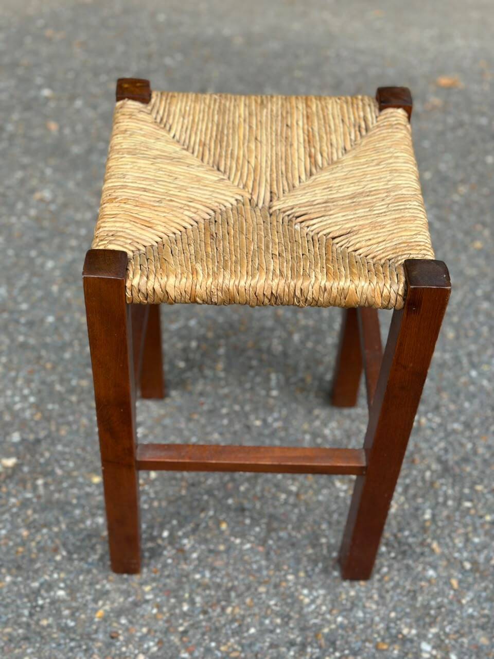 Low stool in brutalist style made of solid wood with straw, 1980.