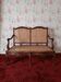 Antique carved solid wood bench with wicker caning.