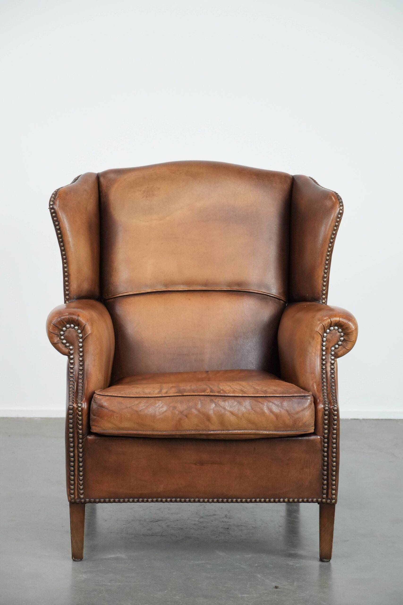 Fauteuil à oreilles en cuir de mouton charmant avec des couleurs chaudes.