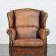 Fauteuil à oreilles en cuir de mouton charmant avec des couleurs chaudes.