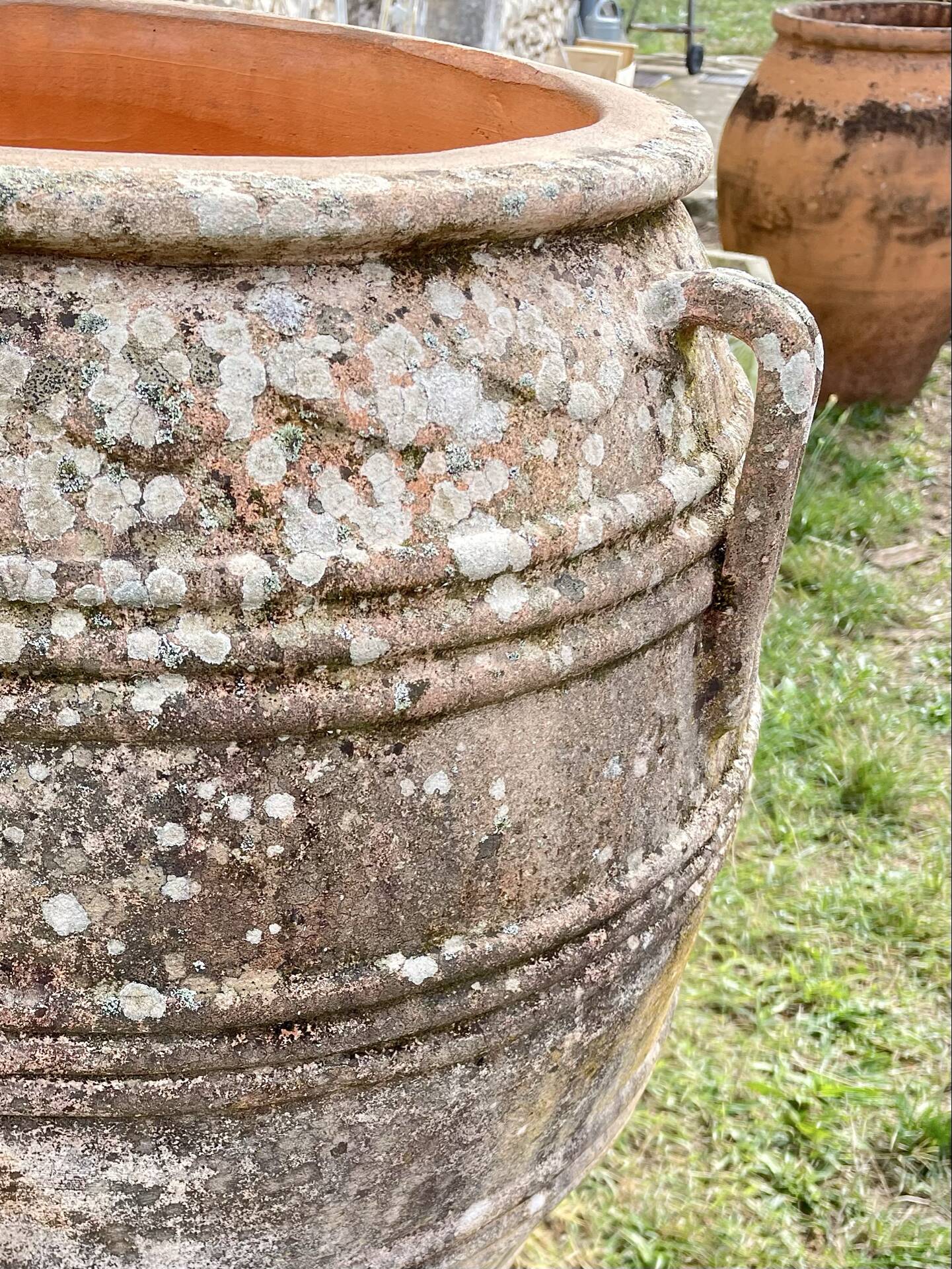 Large Cretan jar in terracotta with three handles on a stone base.