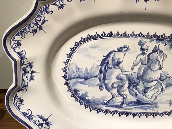Plat ovale en faïence à décor d’une scène de chasse signée