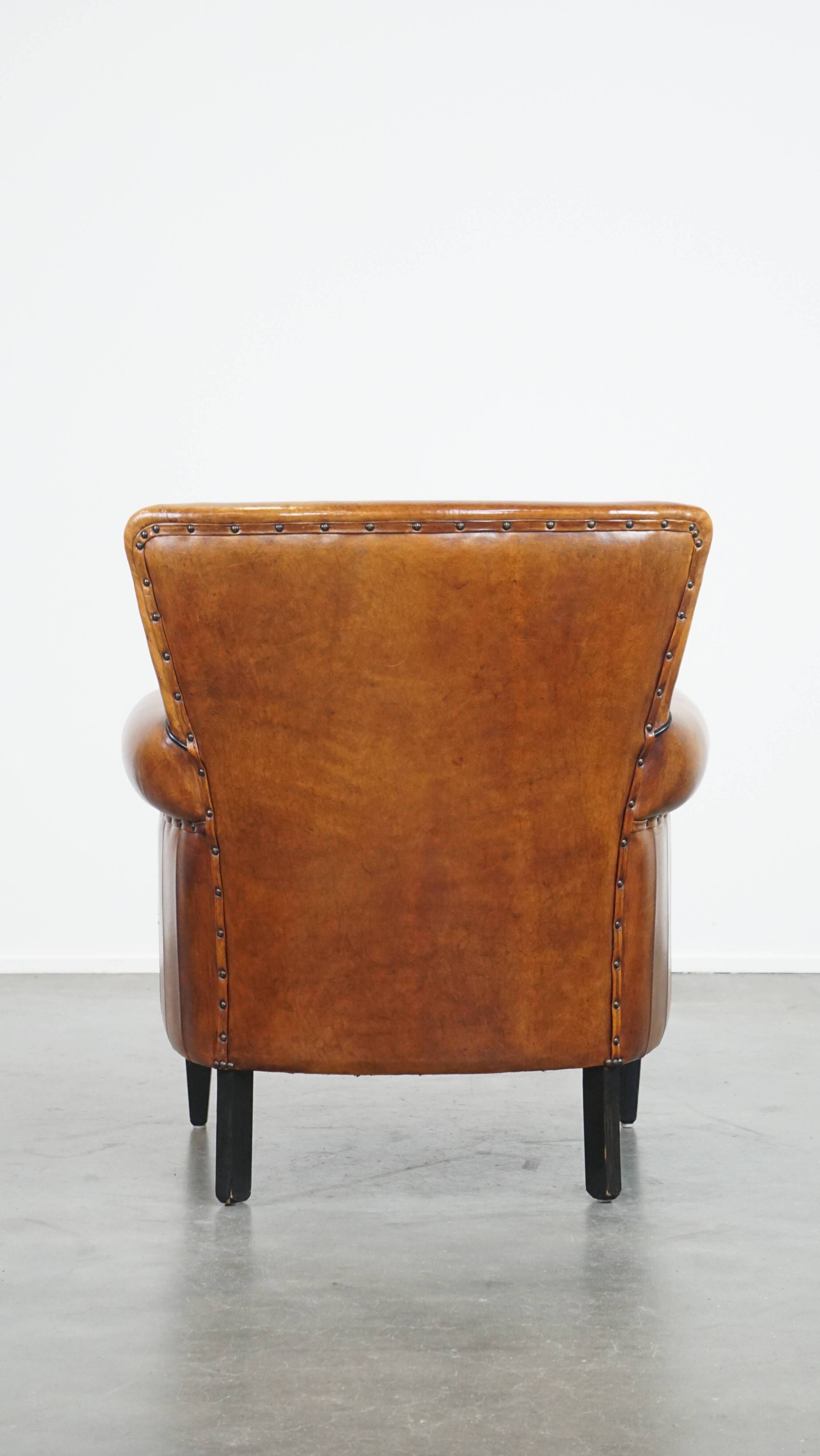 Cognac-colored sheep leather armchair finished with decorative nails