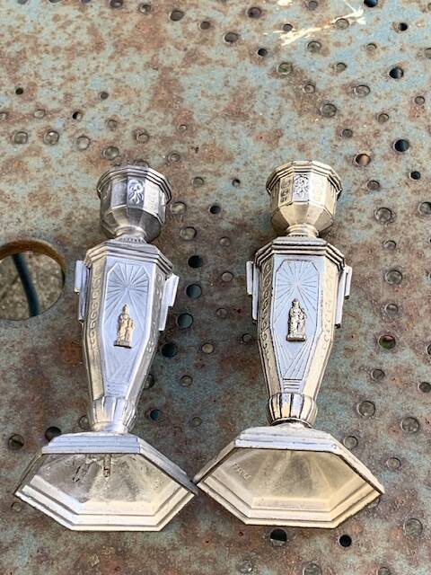 Pair of metal candlesticks, chiseled with a statuette in front, rose pattern in relief, art deco