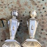 Pair of metal candlesticks, chiseled with a statuette in front, rose pattern in relief, art deco