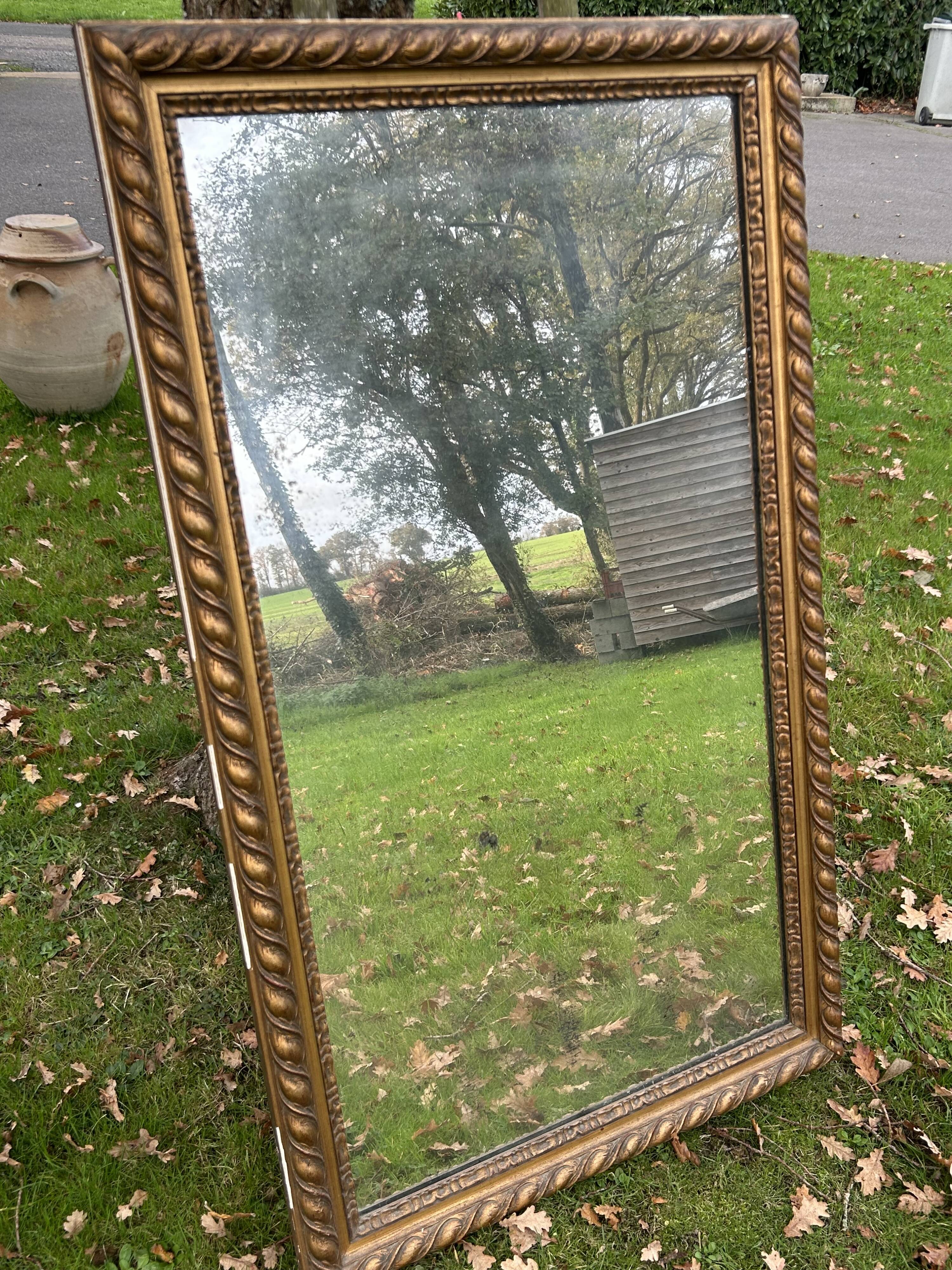 Large antique gilded mirror, wood and stucco gadroons, partially de-mercury