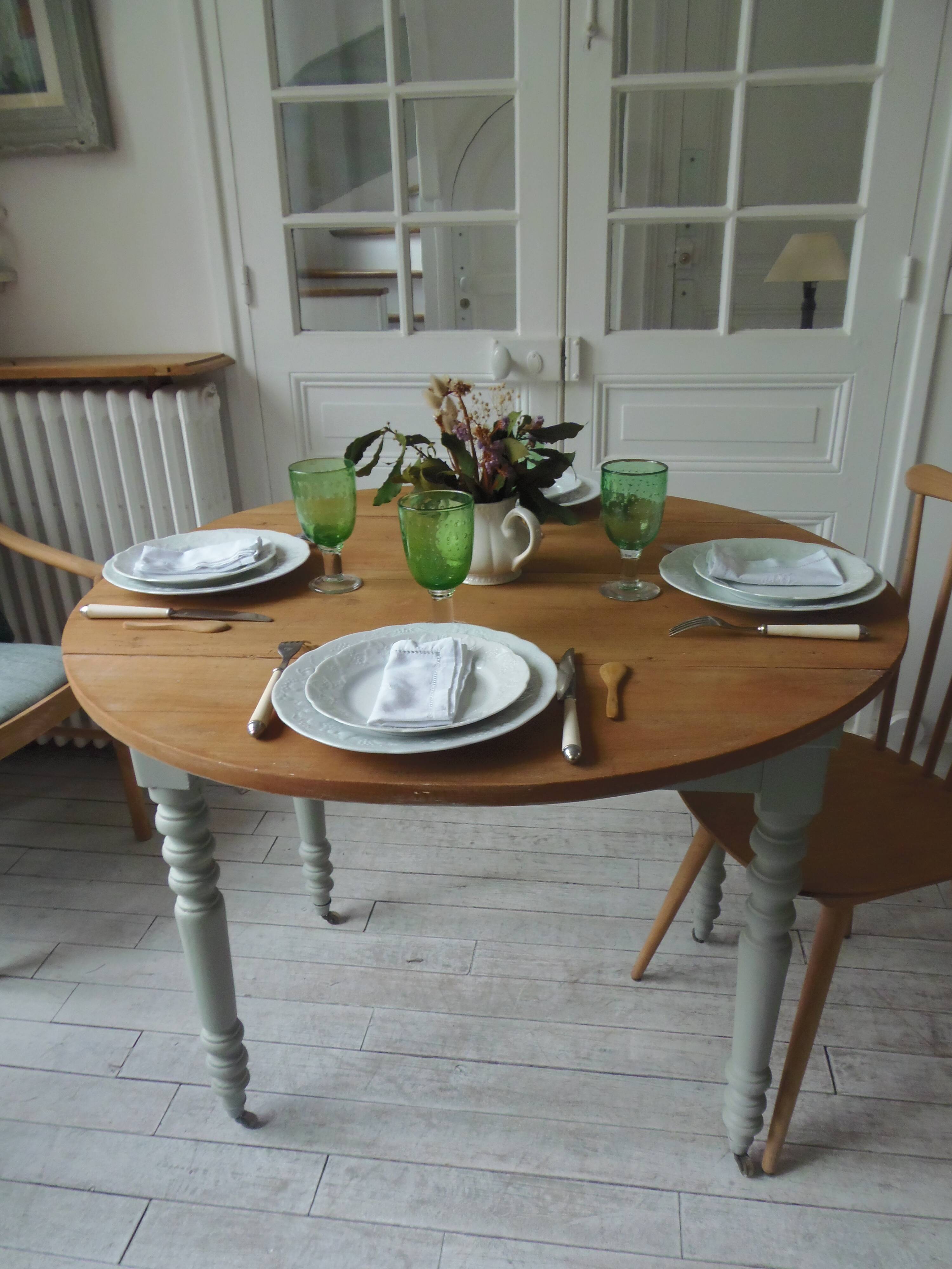 Walnut table with raised flaps, base on verdigris casters.