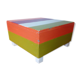 Low wooden stool painted in bright colours